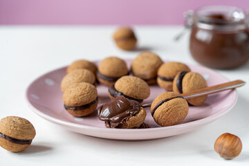 Hazelnut biscuits baci di dama or lady's kisses are traditional Italian dessert made as a sandwich with two cookies and chocolate cream. 