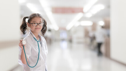Kid's career inspiration and health care, medical insurance concept with girl child in white doctor or nurse lab gown with blurry background medical clinic healthcare service center or hospital