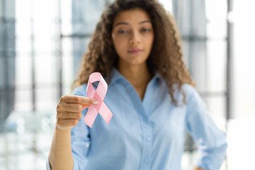 October breast cancer awareness month, woman with hand holding pink ribbon for supporting people...