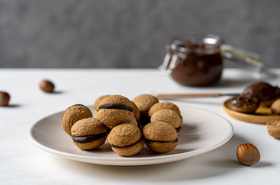 Hazelnut biscuits baci di dama or lady's kisses are traditional Italian dessert made as a sandwich with two cookies and chocolate cream. 