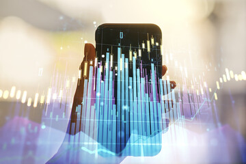 Abstract creative financial graph and hand with phone on background, forex and investment concept. Multiexposure