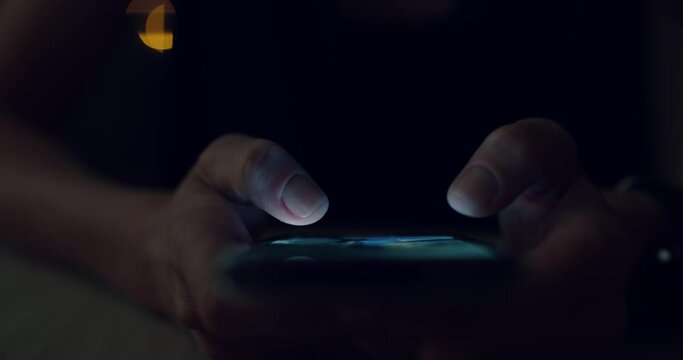 Woman use smartphone in nighttime, type text on touchscreen keyboard and swipe through photos or content on social media.