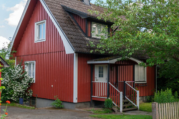 Fototapeta na wymiar Typical red house in Sweden. A beautiful private wooden house in Europe in summer. European architecture, vintage.