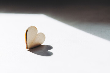 Coeur en bois et ombre coeur dans la lumière du soleil - Photo artistique