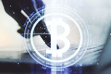 Double exposure of creative Bitcoin symbol with hands typing on laptop on background. Cryptocurrency concept