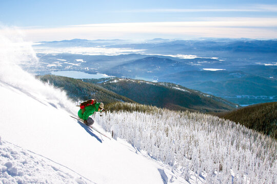Male Skier Makes A Fresh Powder Turn On Snowy Landscape In Whitefish, Montana