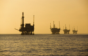 A line of off shore oil rigs at sunset in the Santa Barbara Channel, California, USA.