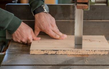 carpenter cutting wood with saw