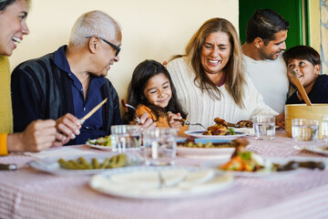 Happy latin family having fun eating together home - Focus on grandmother face