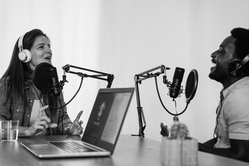 Multiracial hosts streaming podcast at digital studio - Soft focus on female face - Black and white...
