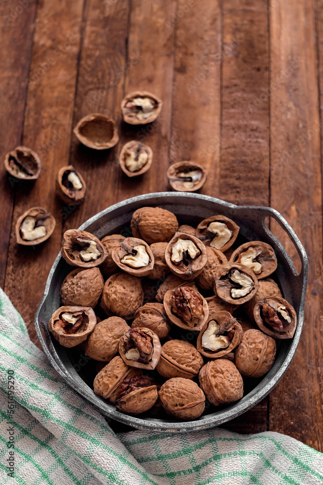 Wall mural Bowl with dried organic walnuts on a wooden table. - Wall murals