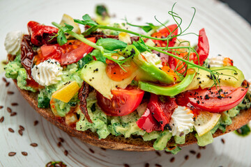 Bruschetta with sun-dried tomatoes, cream cheese, avocado and fresh vegetables.