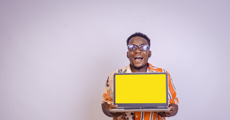 Surprised shocked excited young black African male holding laptop