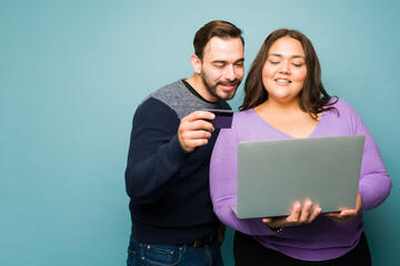 Attractive couple doing online shopping with a credit card