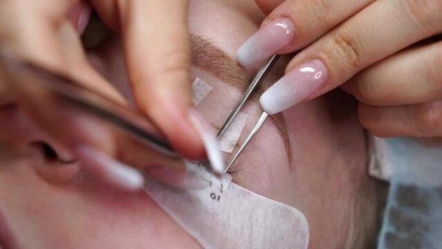 Eyelash extension procedure. Woman eye with long eyelashes. Eyelashes, close-up, macro, selective focus. 4K