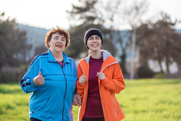 Portrait of happy grandmother and adult granddaughter have fun talking. Family time. Park on the background. International Day of Older Persons