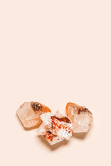 Flat lay bright beige quartz crystals on peach color background. Magic and healing crystal, gem stone, alternative medicine concept. Top view natural gemstone rock, quartz mineral