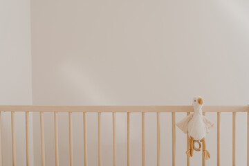 Duck toy in baby crib against white wall - obrazy, fototapety, plakaty