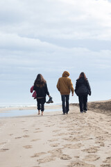 Group of friends walking in the sand.