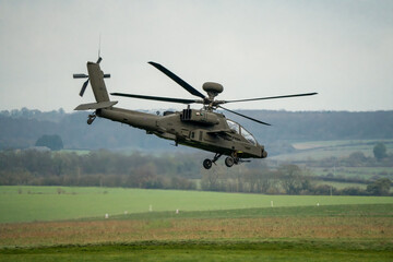 close-up of a British army AH-64E Boeing Apache Attack helicopter (ZM722 ArmyAir606) transitioning to flight on a military exercise, Wilts UK