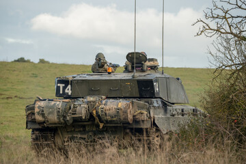 commander and gunner directing action in a British army FV4034 Challenger 2 ii main battle tank on a military combat exercise, Wiltshire UK