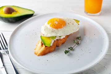 Avocado toast with melted cheese and scrambled eggs