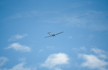 Fototapeta na wymiar a low wing two-seat self-launching motor glider flying in a blue sky