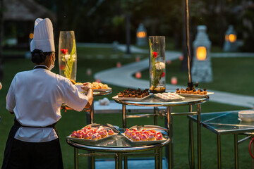 Waiters serving mini canapes pastry desserts during wedding or gala banquet. Beautiful decorated...