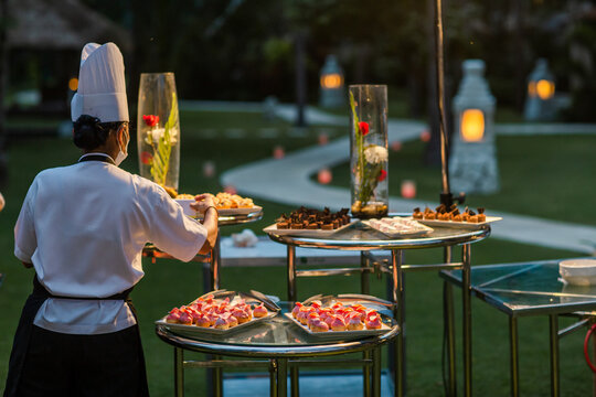 Waiters serving mini canapes pastry desserts during wedding or gala banquet. Beautiful decorated sweet food with fruits
