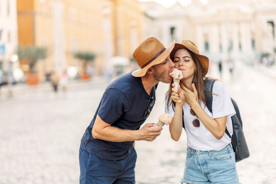 Happy couple eating ice cream in Rome, Italy. Beautiful bright ice cream with different flavors in the hands of a couple. A picture of a happy couple showing ice-cream cones - Powered by Adobe