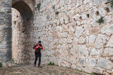 Fototapeta na wymiar front view of a backpacker walking past a medieval castle