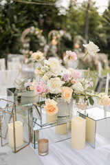 Beautiful table setting with tableware, flowers, candles, accessories and rose centerpiece for a party, wedding reception, gala banquet or other holiday event.