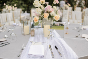 Beautiful table setting with tableware, flowers, candles and accessories for a party, wedding reception, gala banquet or other holiday event.