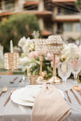Beautiful table setting with tableware, flowers, candles and accessories for a party, wedding reception, gala banquet or other holiday event.