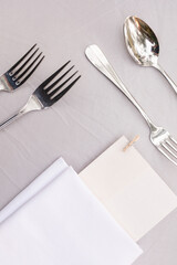 Classic table settings for fine dining with cutlery, plates, napkins and paper menu. Props for events, weddings, birthdays, gala banquet.