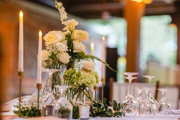 Beautiful table setting decorated with lighted candles, tableware, flowers, accessories for a party, wedding reception, gala banquet or other holiday event. - 561507487