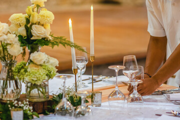Close up of waiter preparing the festive table for a party, wedding reception, gala banquet or other holiday event.