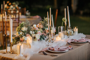 Beautiful table setting with tableware, flowers, candles, accessories and rose centerpiece for a...