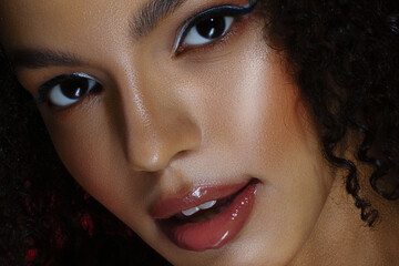 Close-up of beautiful young woman. Arrows, glowing dark skin, wet lip gloss - obrazy, fototapety, plakaty