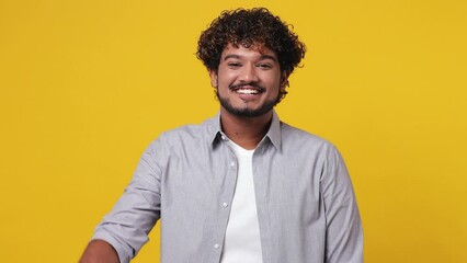 Young fun promoter Indian man 20s wear casual grey shirt pointing indicate index finger down on workspace area copy space mock up isolated on plain yellow background studio. People lifestyle concept - Powered by Adobe