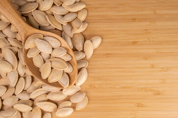 Roasted Shelled Pumpkin Seeds in A Wooden Spoon On A Wooden Background And Copy Space, Empty.