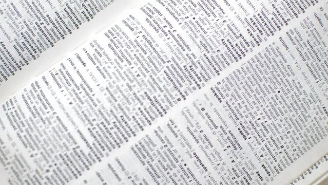 caucasian student's hand using english dictionary for language learning.