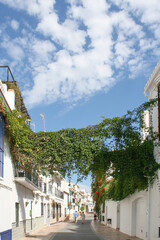 An unidentified couple walk down a typical street in the small beach town or Nerja, Spain on a...