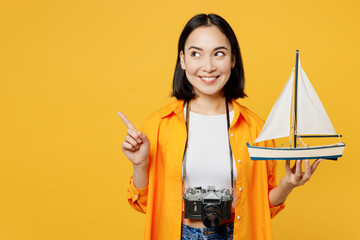 Young woman wear summer casual clothes hold ship mockup point finger aside isolated on plain yellow...
