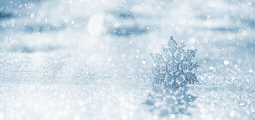 Christmas winter background, banner with copy space for text - view of an decorative snowflake on a snowdrift in a winter forest, double exposure photo