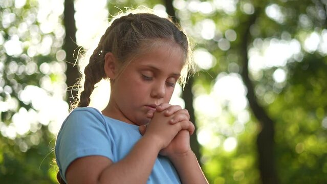 child pray. young gratitude a god religion concept. little girl in nature outdoors praying lifestyle dreams of happiness to god. praise worship freedom concept. kid praying in the forest