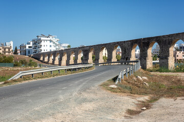 Fototapeta na wymiar Old Kamares Aqueduct or Bekir Pasha Aqueduct near Larnaca, Cyprus. Scenic view of historical landmark and popular tourist attraction, distinctive arches in Roman style, outdoor travel background