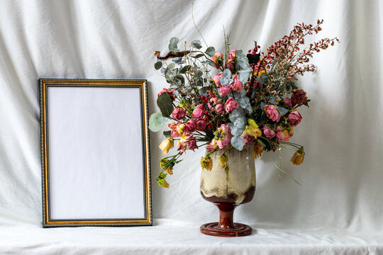Photo frame mockup with dried dry flowers in a vase, still life