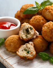 Mini Chicken kiev breast stuffed with a cream and garlic filling on wooden white board