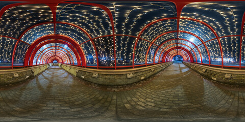 spherical night 360 panorama in festively lit underground passage tunnel with red frame arch and...
